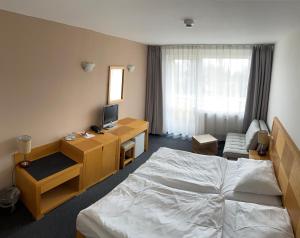 a hotel room with a bed and a desk at Lipno-Frymburk Wellnes APT D 103 in Frymburk