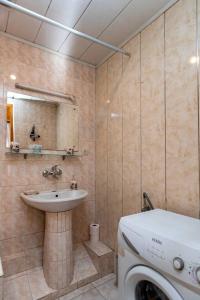 a bathroom with a sink and a washing machine at Wehost Cozy and colorful apartment with balcony in Tbilisi City