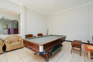 a living room with a pool table in it at SUPER OYO 2075 Graha Marina in Surabaya