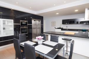 una cocina con electrodomésticos en blanco y negro, mesa y sillas en LA CASA DE ANVER, en La Lastrilla