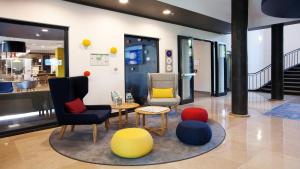 a lobby with chairs and a table andools at Holiday Inn Express - Saarbrücken by IHG in Saarbrücken