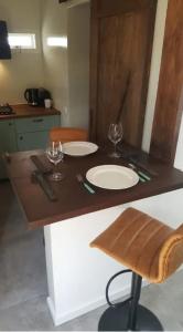 stół z dwoma talerzami i kieliszkami do wina w obiekcie Tiny Beachstudio w mieście Noordwijk