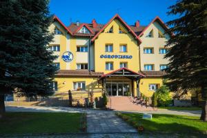 a large yellow building with a staircase in front of it at Hotel *** NAT Wisła in Wisła