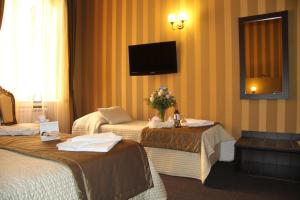 ローマにあるDomus RomAnticaのベッド2台、壁掛けテレビが備わるホテルルームです。