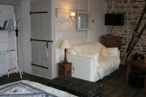 Les Pierres Davélie في Saint-Éloy-la-Glacière: غرفة معيشة بها أريكة بيضاء وتلفزيون