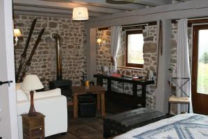 a room with a bed and a stone wall at Les Pierres Davélie in Saint-Éloy-la-Glacière