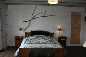 a bedroom with a bed with a tree branch on the wall at Les Pierres Davélie in Saint-Éloy-la-Glacière