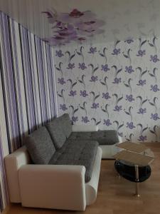 sala de estar con sofá blanco y flores púrpuras en la pared en Ahtme apart, en Kohtla-Järve