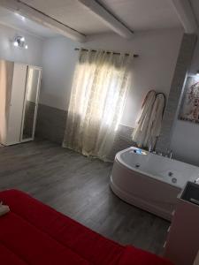 een grote badkamer met een bad en een raam bij Villa Suite Deluxe in Siracusa