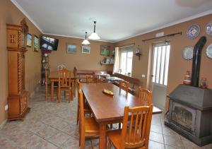 a dining room with a table and chairs and a fireplace at Pensión Casa Elena in Reinante
