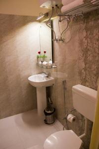 y baño con lavabo, aseo y espejo. en Hotel Park Riviera, en Guwahati