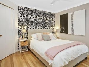 a bedroom with a bed with a black and white wallpaper at SEAVIEW - ocean views from a modern townhouse in Apollo Bay