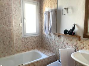 a bathroom with a tub and a window and a sink at Apartamentos Sabica in Sierra Nevada