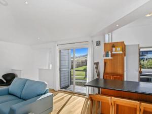 a living room with a blue couch and a table at SEAVIEW - ocean views from a modern townhouse in Apollo Bay
