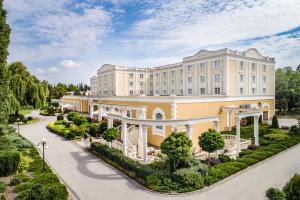 an exterior view of a large building with a driveway at Hotel Windsor w Jachrance in Jachranka