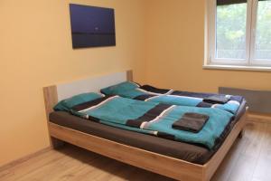 a bed in a room with a tv on the wall at Tisza Villa in Abádszalók