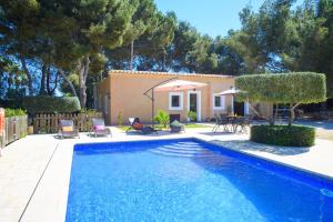 a swimming pool with chairs and a house at Finca Naveta in Cala Ferrera