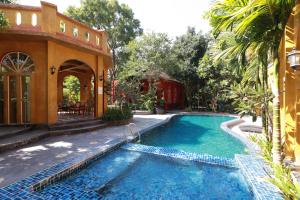 a swimming pool in a yard with a house at Capital O 469 At Nata Chiangmai Chic View in Mae Rim