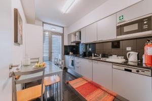 a kitchen with white cabinets and a counter top at Cozy T2 with Ocean View in Funchal