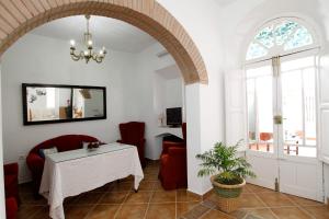 Casa Rural Mérida في Aljucén: غرفة معيشة مع طاولة وكراسي ونافذة
