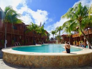 una mujer sentada frente a una piscina en Cabañas Coconut by MIJ, en Isla Holbox