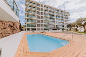 a building with a swimming pool in front of a building at Cozy T2 with Ocean View in Funchal