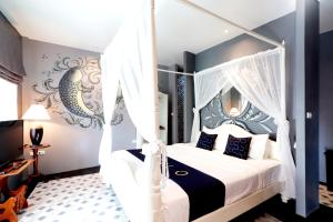 a bedroom with a white canopy bed with blue accents at Capital O 469 At Nata Chiangmai Chic View in Mae Rim