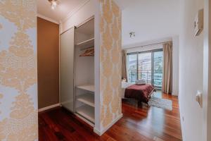 a room with a closet and a bedroom with a bed at Cozy T2 with Ocean View in Funchal +24 photos