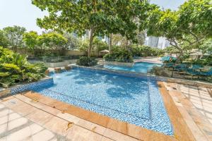 an empty swimming pool with trees and blue water at Divine Burj & Opera Views - 2BDR - DOWNTOWN DUBAI in Dubai