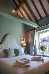 a bedroom with a bed with towels on it at The Horse and Groom Inn in Chichester