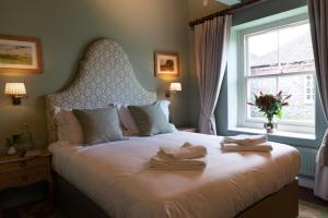 1 dormitorio con 1 cama grande y toallas. en The Horse and Groom Inn, en Chichester