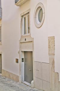 ein weißes Gebäude mit einer Tür und einem runden Fenster in der Unterkunft Lisbon Combro 77 Charming Studios by Get Your Stay in Lissabon