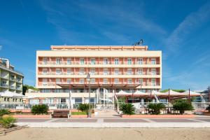 a hotel building with a beach in front of it at Hotel Columbus in Caorle