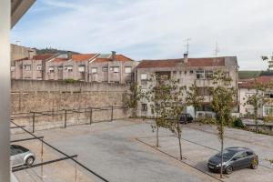 ein Parkplatz mit Autos vor den Gebäuden in der Unterkunft Old Market Apartment in Guimarães