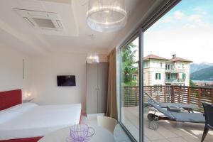 a bedroom with a bed and a balcony at Residence Lenno in Lenno