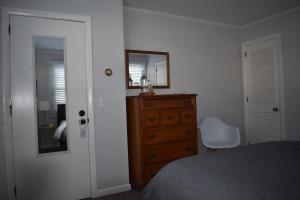 een slaapkamer met een bed, een dressoir en een spiegel bij The Little River Inn in Stowe