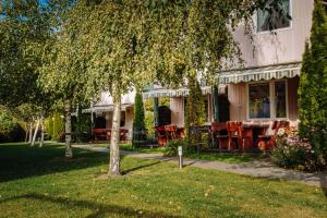a house with tables and chairs in the yard at Ośrodek domków letniskowych Sztorm in Chłopy