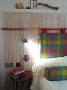 ein Schlafzimmer mit einem Bett und einem Tisch mit Büchern in der Unterkunft Blas Rooms in Dunvegan