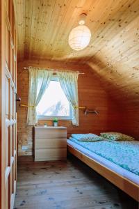a bedroom with a bed in a wooden house at Ośrodek domków letniskowych Sztorm in Chłopy +48 photos