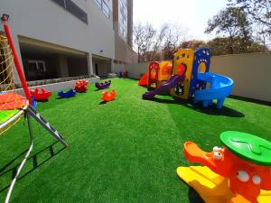 Un patio de juegos con equipos de juego en el césped. en RIO QUENTE PARK VEREDAS Flat, en Rio Quente