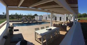 a patio with a table and chairs and a swimming pool at HelloApulia - Trullo Bello in Martina Franca