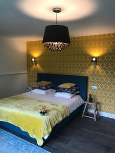 a bedroom with a large bed and a chandelier at B&B De Hanewijkhoeve in Werchter +20 photos