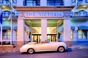 a white car parked in front of a building at AX The Victoria Hotel in Sliema