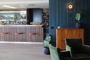 a bar in a restaurant with blue walls and chairs at Hotel Lyngørporten in Gjeving