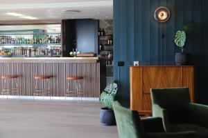 eine Bar in einem Restaurant mit blauen Wänden und Stühlen in der Unterkunft Hotel Lyngørporten in Gjeving