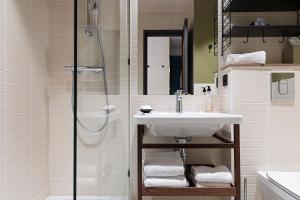 a bathroom with a sink and a shower at Hôtel Des Artistes in Lyon +43 photos