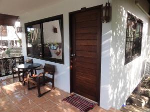 a porch with a wooden door and a table at High Life Bungalow in Haad Yao
