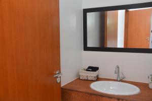 uma casa de banho com um lavatório e um espelho em Pousada la Boheme Guarda do Embaú - SC em Guarda do Embaú