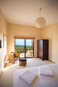 a bedroom with a bed and a view of the ocean at Redgate Beach Escape in Witchcliffe