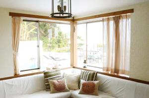 a white couch in a room with a large window at Gardenvilla Shirahama in Shimoda